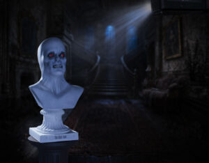 The Ghost Bust Halloween projection prop with illuminated projector in gothic haunted house interior